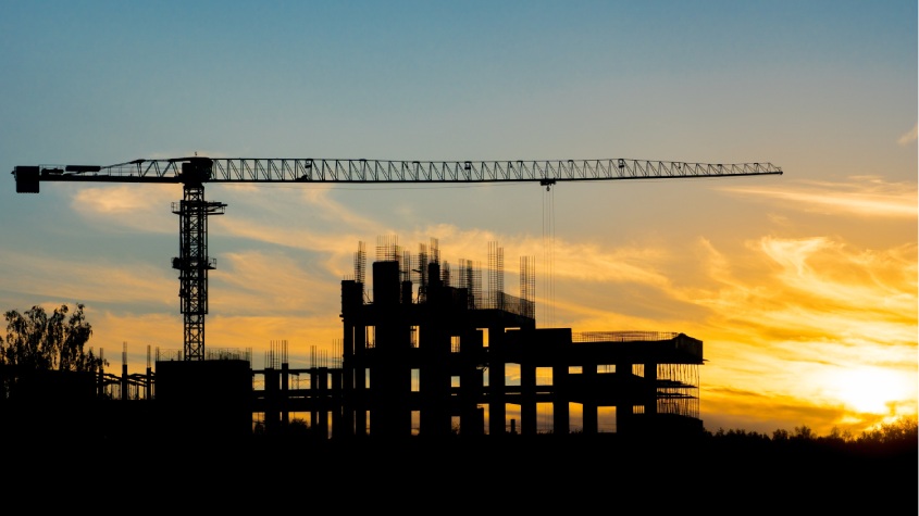 Crane and building under construction, example of a GMP contract in construction focused on budget control and risk reduction